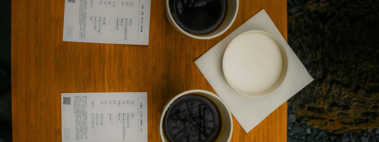 Deux feuilles imprimées et deux tasses de café posées sur une table en bois