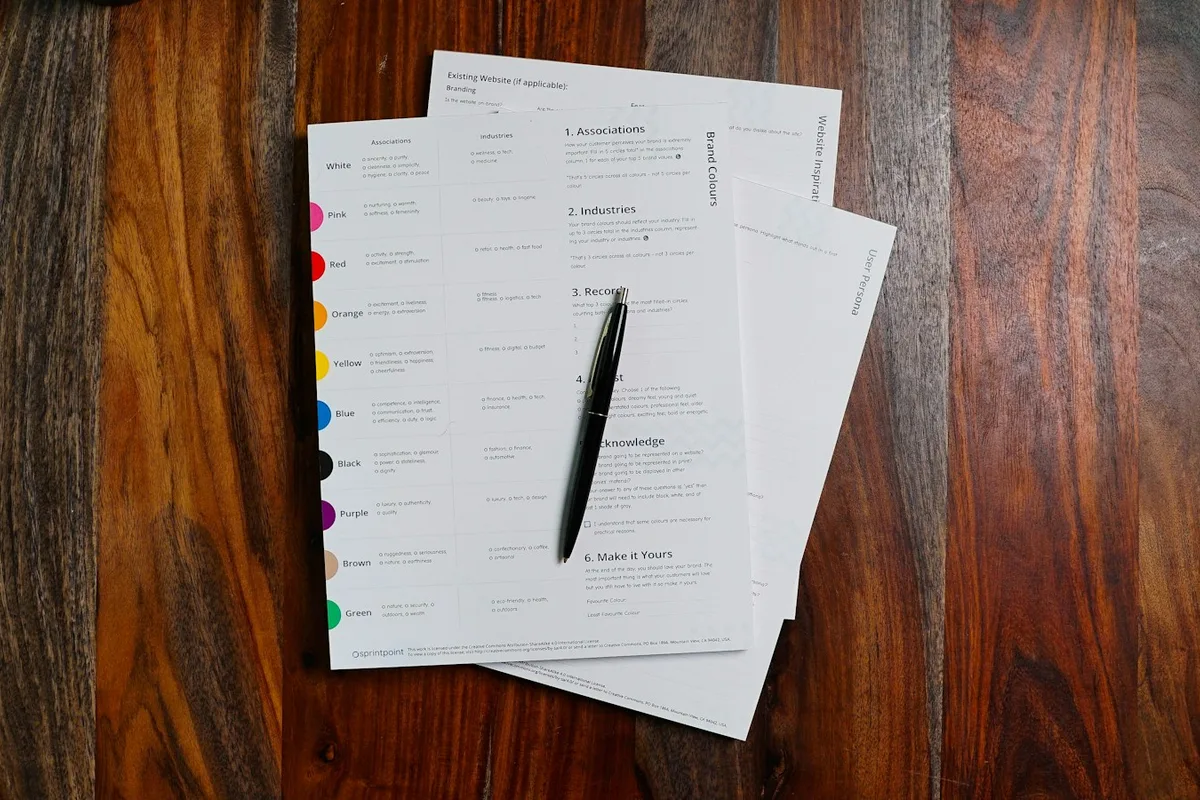 Documents imprimés et stylo posés sur une table en bois, prêts pour vérification