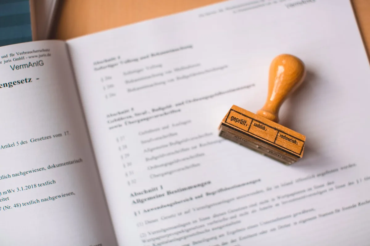 Un tampon en bois posé sur un document officiel imprimé et ouvert