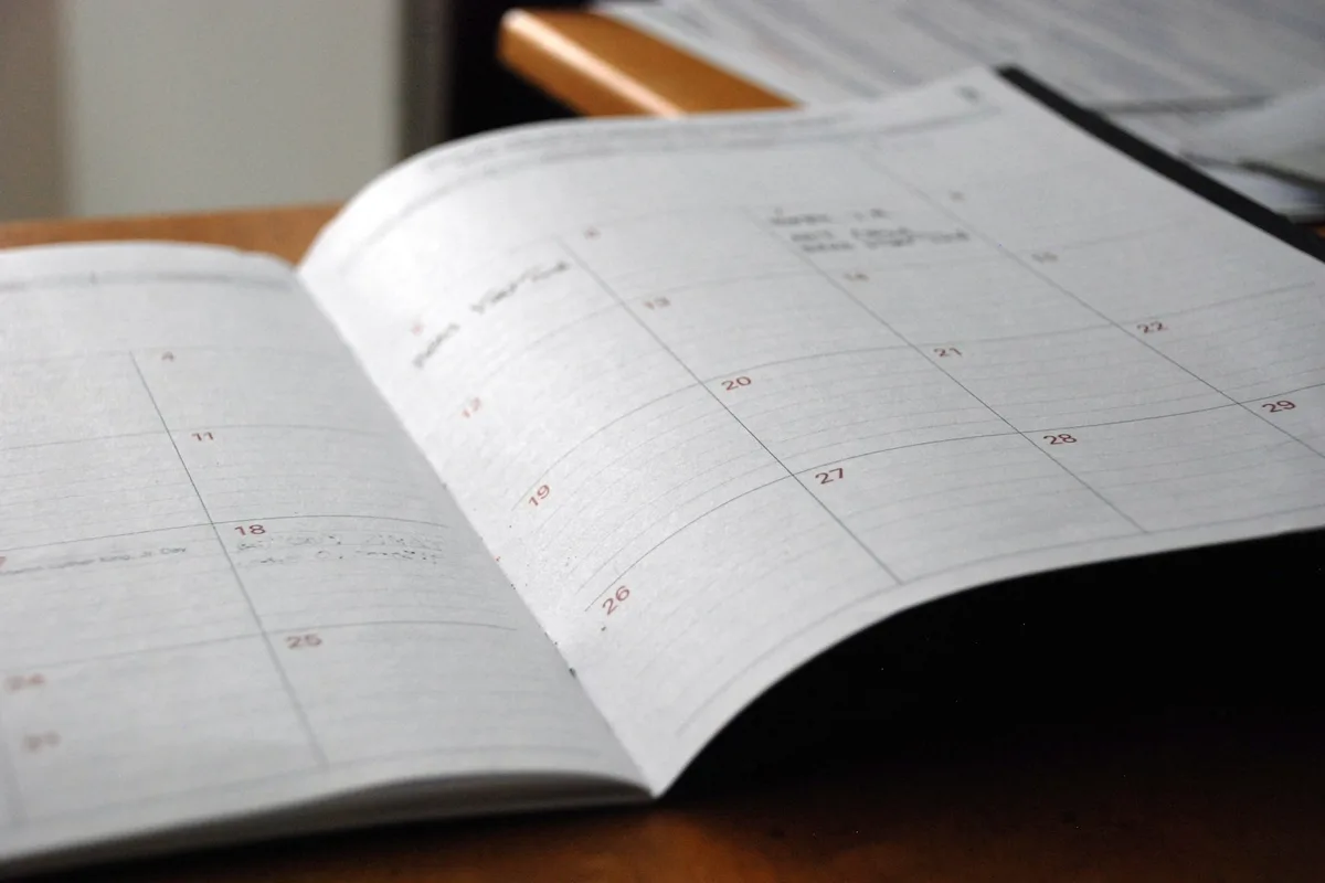 Calendrier annoté posé sur un bureau avec les périodes d'envoi marquées