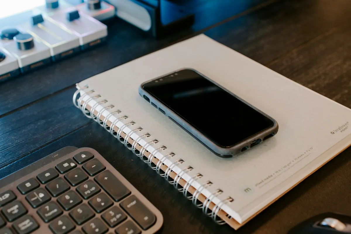 Téléphone posé sur un carnet à côté d'un clavier, poste de réponse aux messages