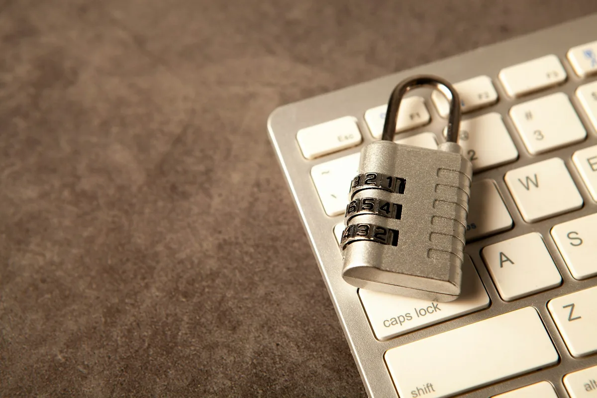 Un cadenas fermé posé sur le clavier noir d'un ordinateur portable