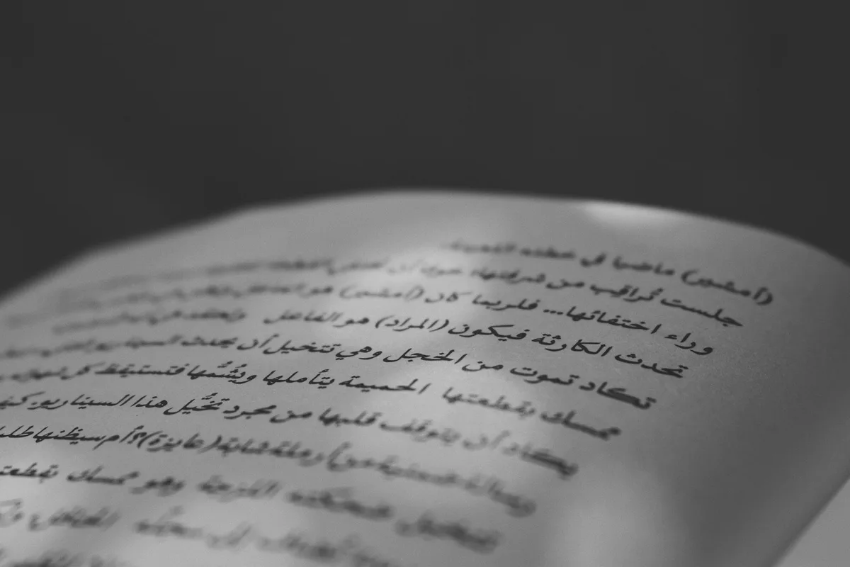 Page d'un livre en arabe ouverte, lignes de texte nettes en gros plan