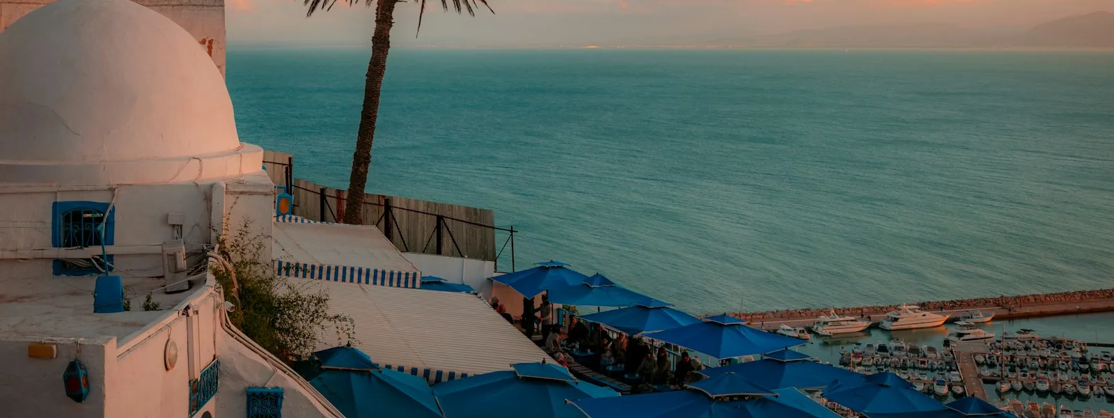 Vue sur la mer depuis Sidi Bou Said, coupole blanche et parasols bleus d'un café