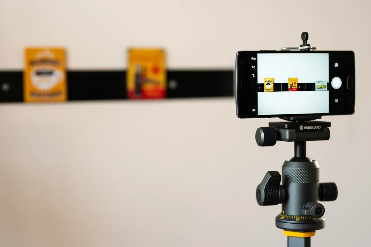 Un téléphone sur support photographie de petits produits alignés sur une barre