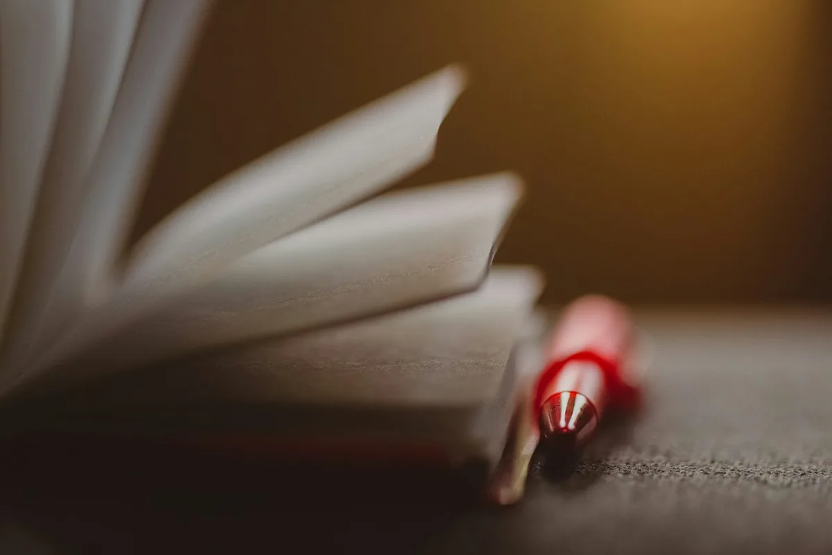 Feuille imprimée annotée au crayon rouge avec des flèches et des entourages sur un bureau