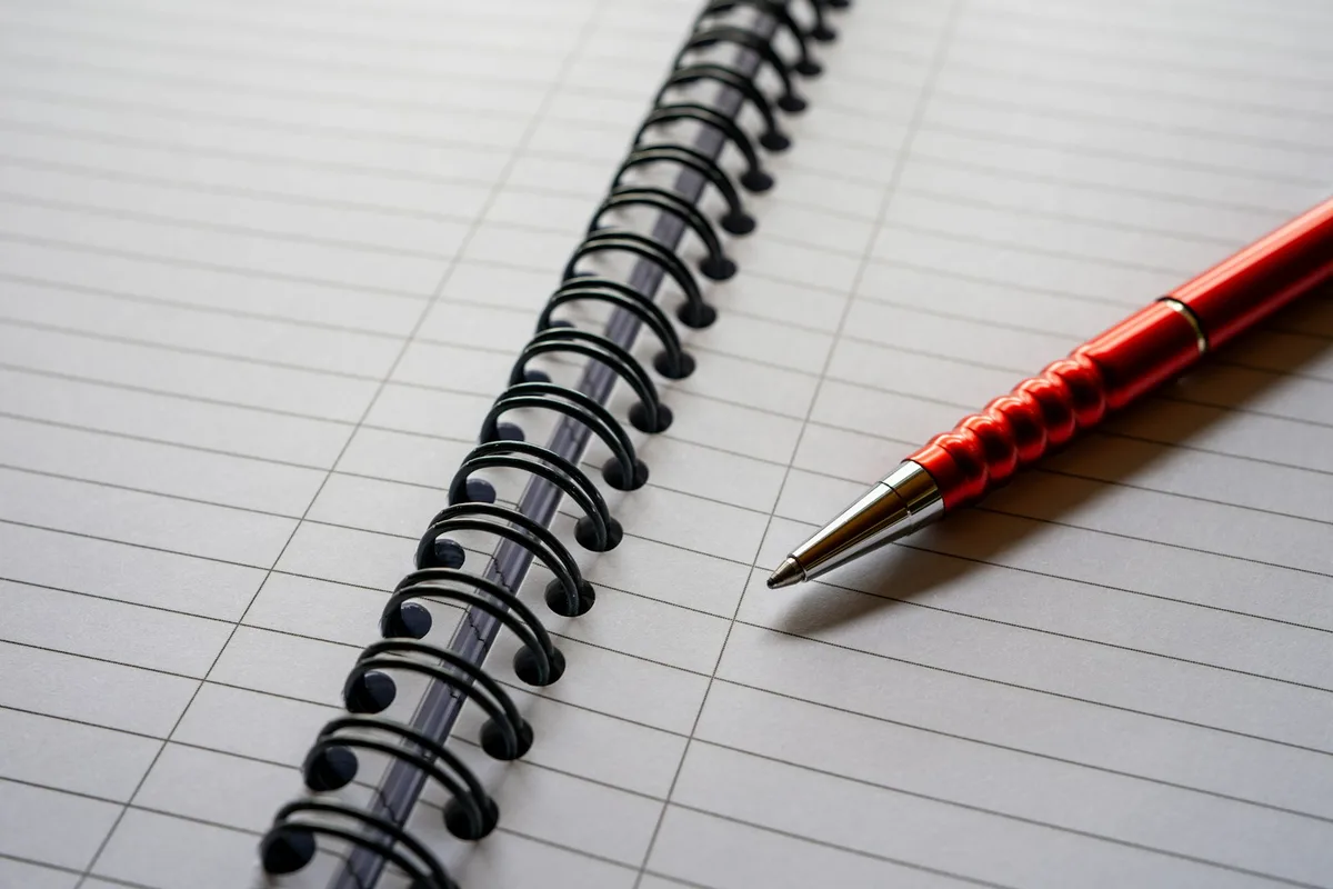 Page imprimée couverte de corrections au stylo rouge posée près d'une tasse de café