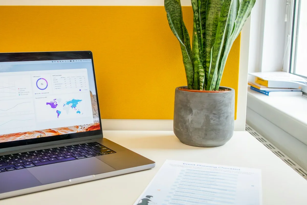 Ordinateur portable affichant un tableau de suivi, à côté d'une feuille imprimée