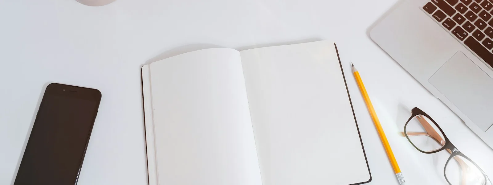 Téléphone affichant un formulaire court posé sur un bureau à côté d'un carnet