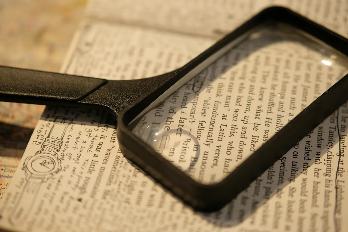 Loupe posée sur une page imprimée, un passage agrandi sous la lentille
