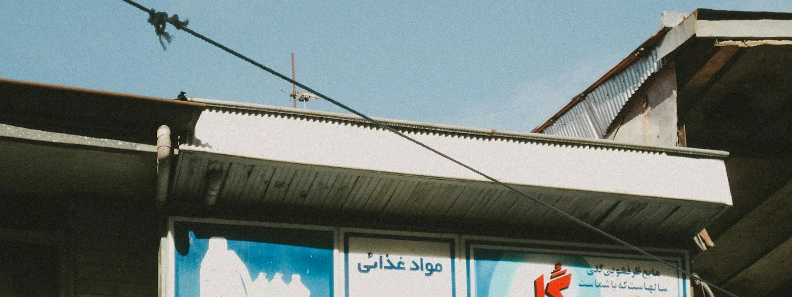Enseigne peinte d'un commerce dans une rue tunisienne, signe visible de notoriété locale