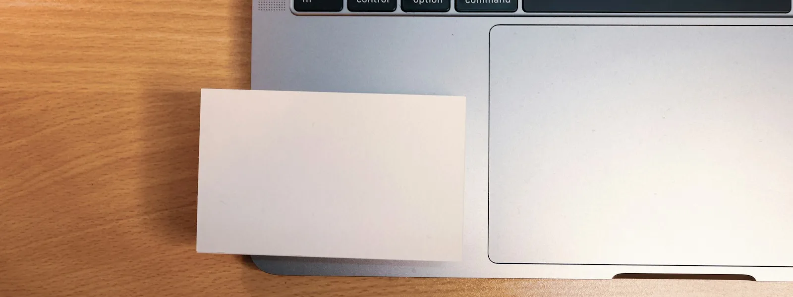 Ordinateur portable ouvert sur une table de réunion à côté d'un bloc-notes et de cartes de visite