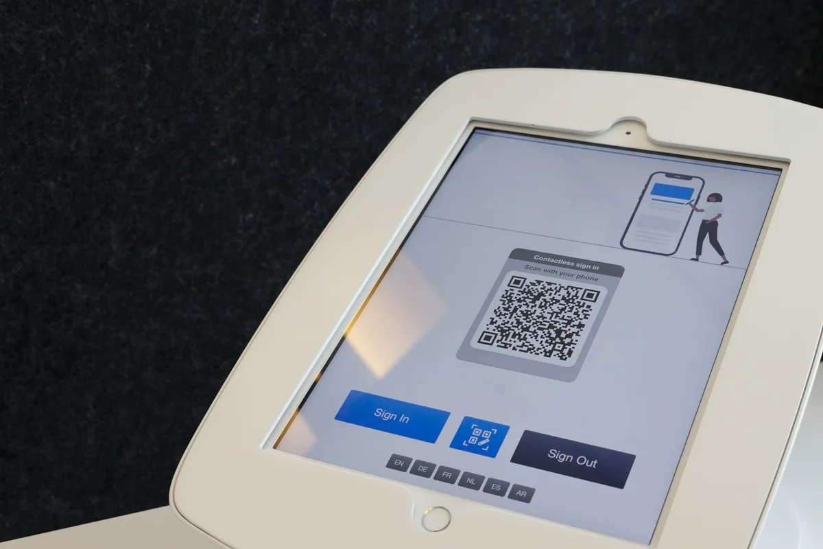 Affichette de comptoir portant un code carré imprimé, posée à côté d'un téléphone