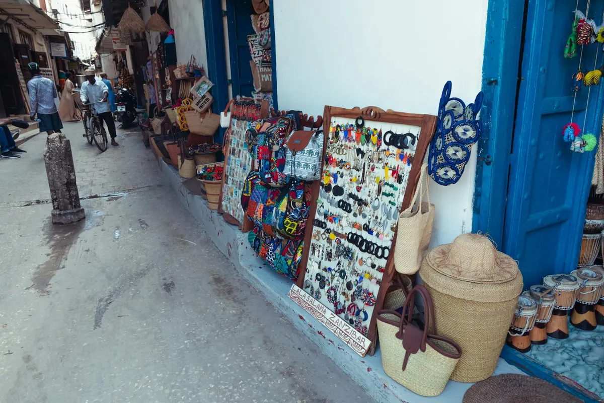 Rue commerçante tunisienne avec des enseignes et des devantures alignées vue de loin