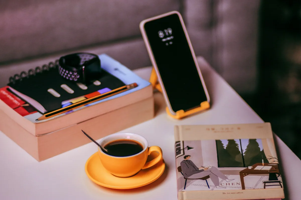 Téléphone en position verticale sur un support diffusant une vidéo sur une table de café