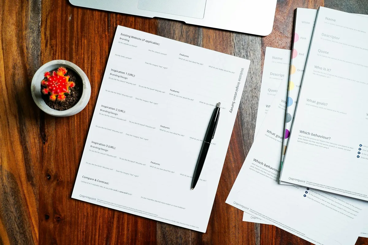 Feuilles imprimées et stylo posés sur une table en bois, prêtes à être annotées
