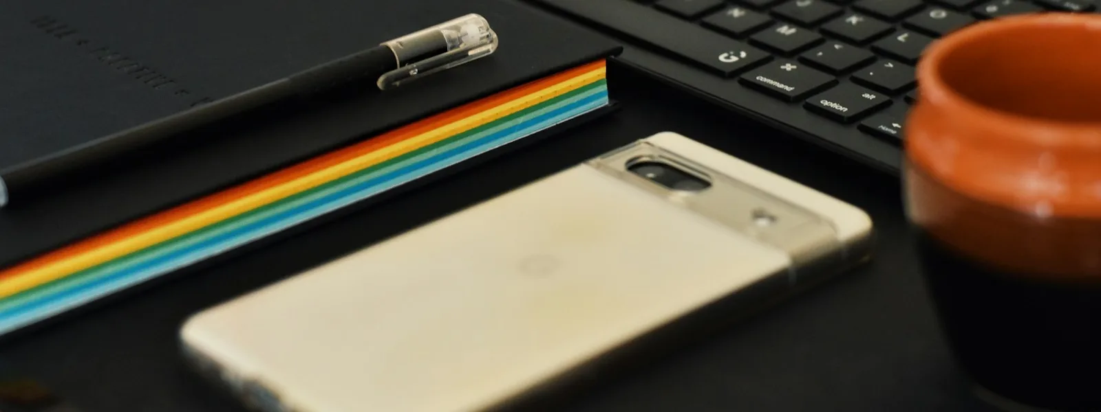 Carnet, stylo, téléphone et clavier posés sur un bureau avant l'ouverture du compte