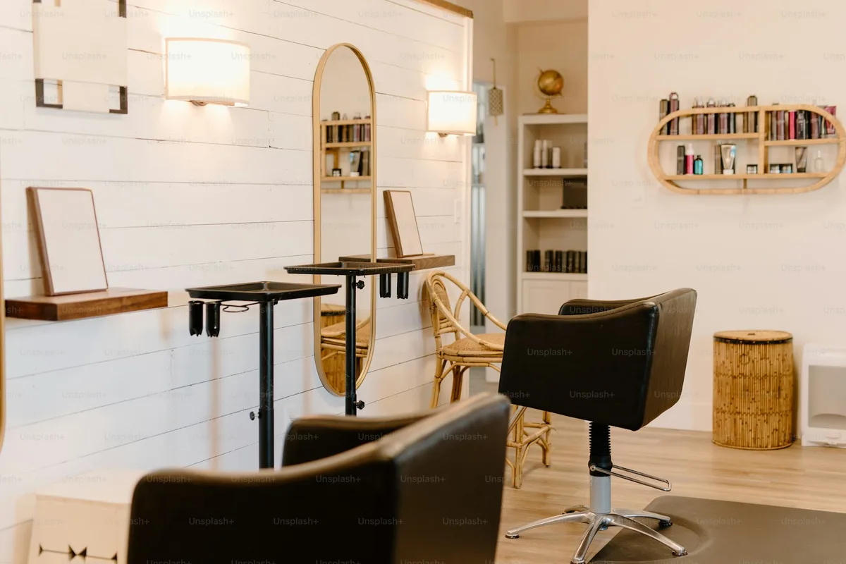 Fauteuils de coiffure vides devant les miroirs d'un salon clair et récent