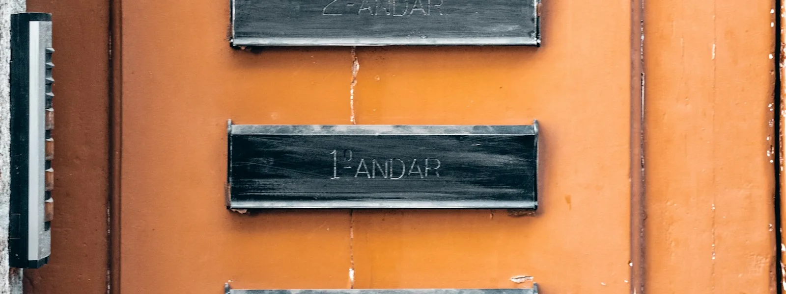 Plaque professionnelle en laiton vissée sur le mur d'entrée d'un immeuble