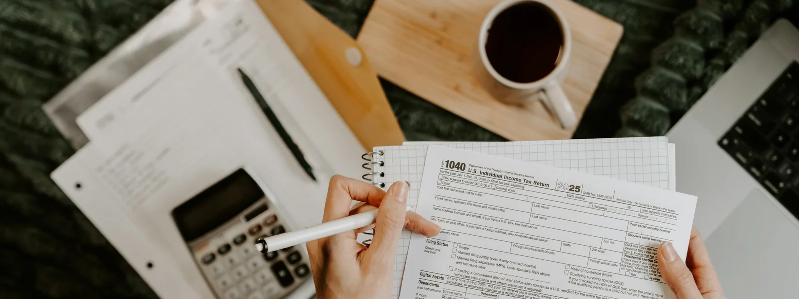 Des mains rapprochent des relevés chiffrés à l'aide d'une calculatrice sur un bureau