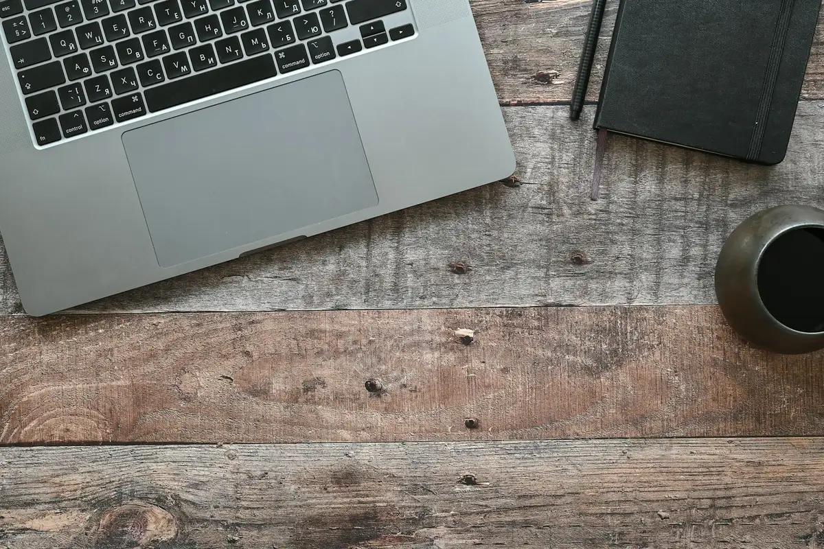 Un clavier d'ordinateur vu de haut avec une tasse de café posée à côté