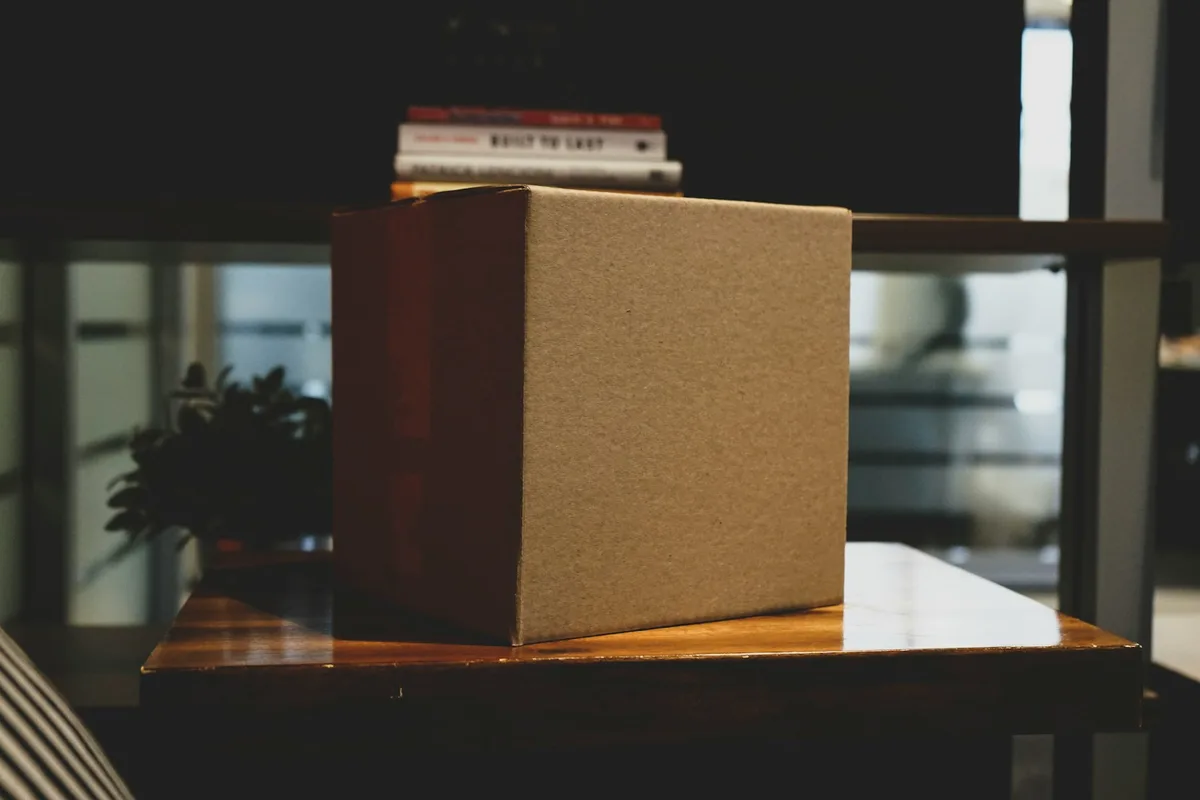 Un carton d'expédition vierge posé sur un plan de travail en bois