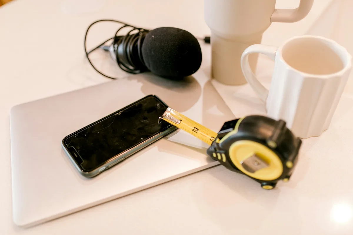 Micro-cravate et câble posés sur une table à côté d'un téléphone près d'une fenêtre